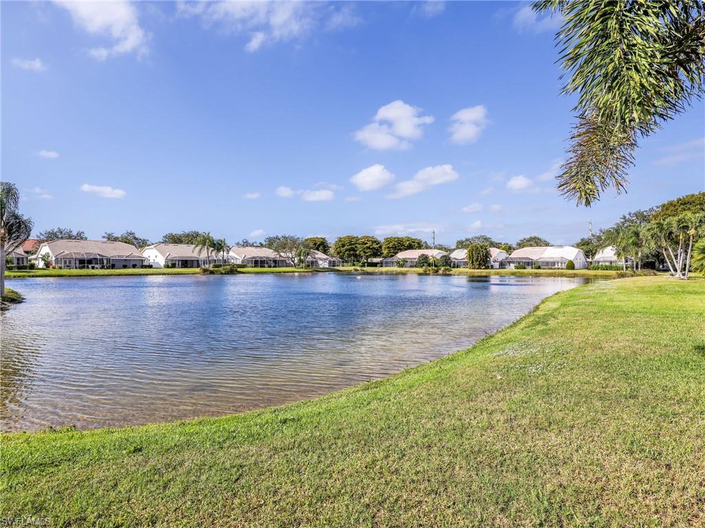 2214 Stacil Circle, Unit 27 Naples, FL 34109 - Photo 30 of 39 a view of a lake with houses in the background