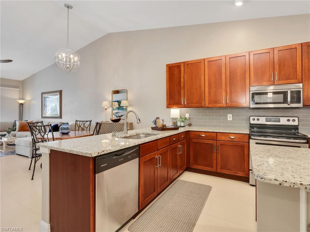 2214 Stacil Circle, Unit 27 Naples, FL 34109 - Photo 39 of 39 a kitchen with stainless steel appliances granite countertop a sink dishwasher stove top oven and cabinets with wooden floor