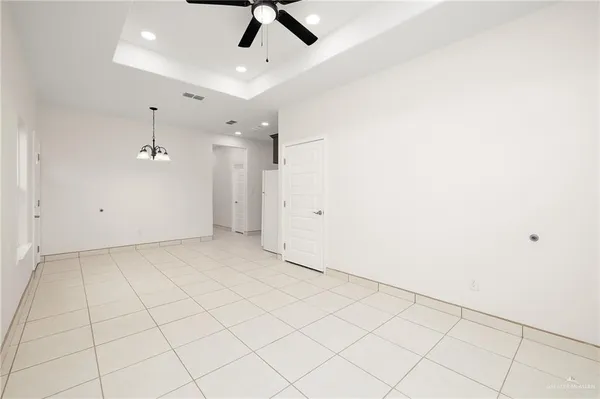 an empty room with chandelier fan