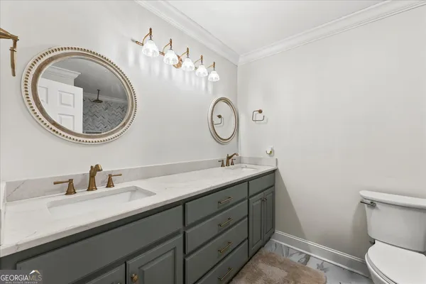 a bathroom with a granite countertop toilet a sink and mirror