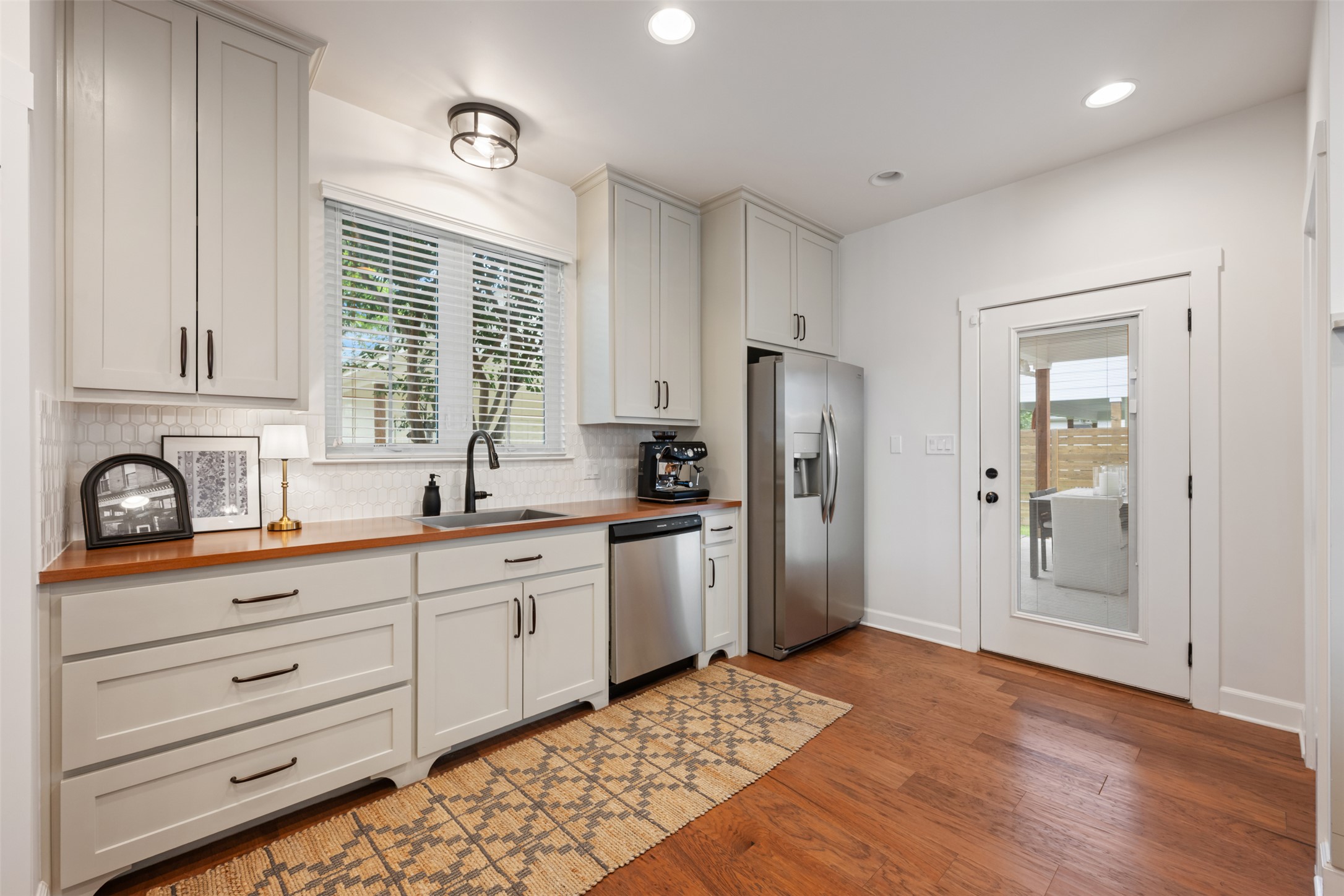 1301 West Street Georgetown, TX 78626 - Photo 13 of 40 A sleek, contemporary kitchen with warm wood floors and stainless steel appliances.