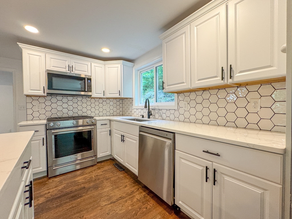 282 Pleasant Street Marblehead, MA 01945 - Photo 15 of 28 a kitchen with granite countertop white cabinets stainless steel appliances a sink and a window