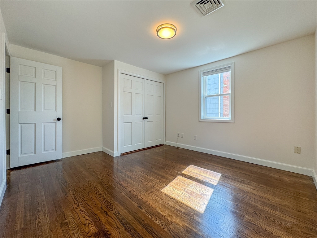 282 Pleasant Street Marblehead, MA 01945 - Photo 17 of 28 an empty room with wooden floor and windows