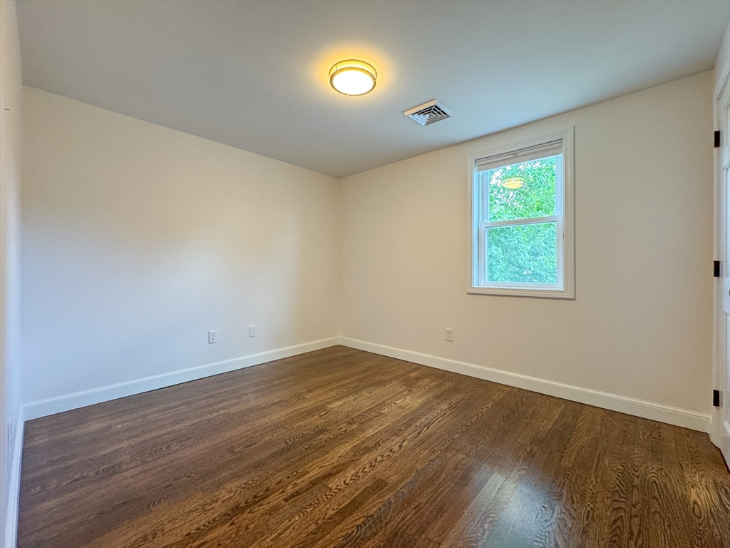 282 Pleasant Street Marblehead, MA 01945 - Photo 20 of 28 a view of an empty room with wooden floor and a window