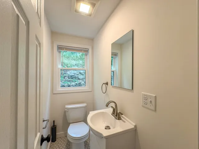 a bathroom with a toilet sink and mirror