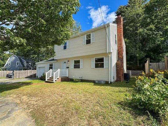 a view of a house with backyard and sitting area