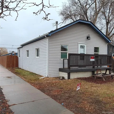 a view of backyard with wooden fence and a large tree