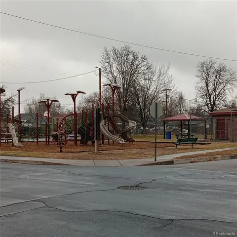 a white house that has a bench and white fence
