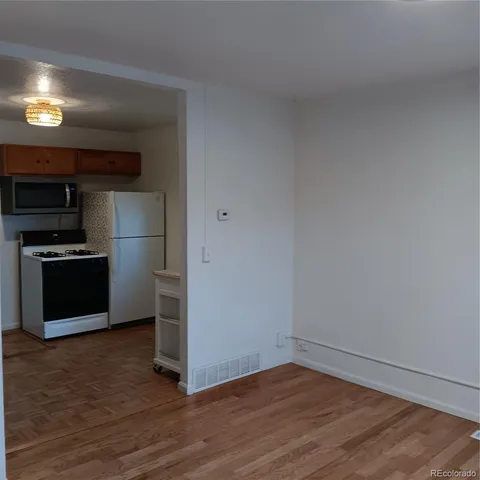 a view of a kitchen with wooden floor and electronic appliances