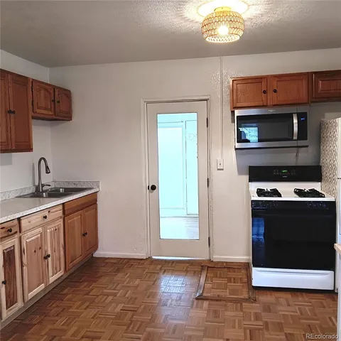 a kitchen with granite countertop a stove and a refrigerator