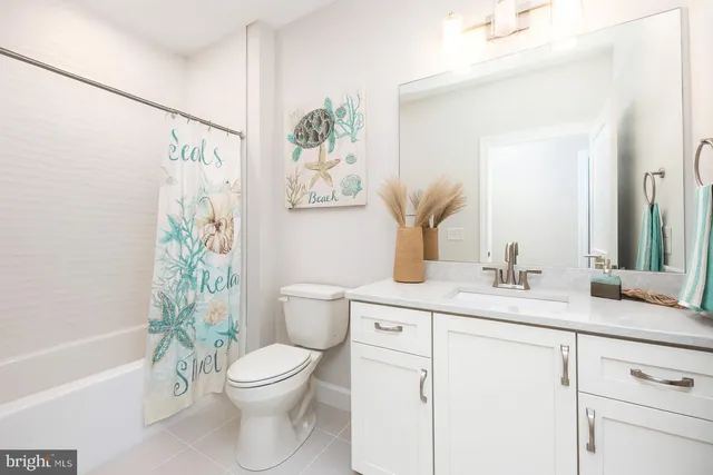 a bathroom with a granite countertop sink a toilet and a bathtub