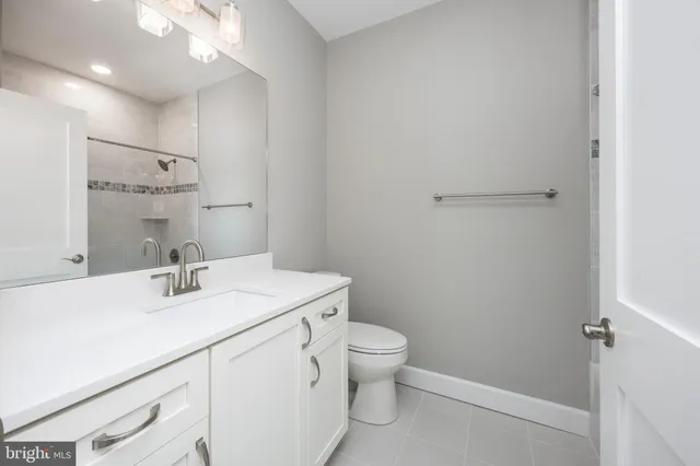a bathroom with a sink vanity mirror and toilet