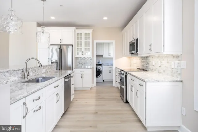 a large kitchen with stainless steel appliances kitchen island granite countertop a sink and cabinets