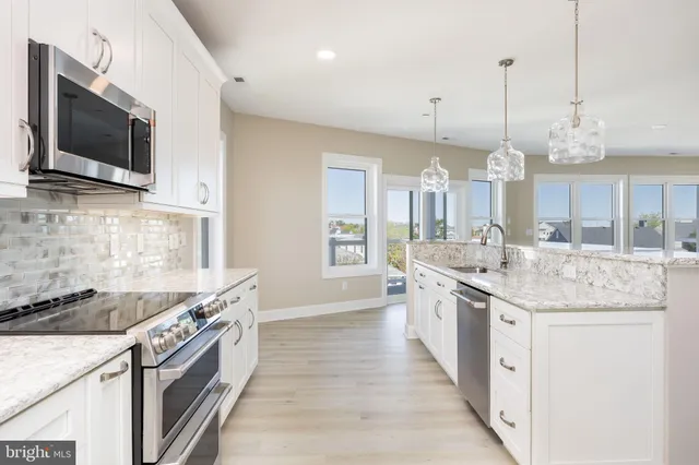 a large kitchen with granite countertop a stove and a sink