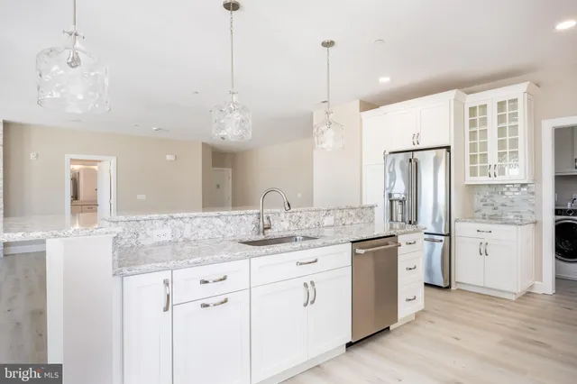 a bathroom with a granite countertop sink a large mirror a toilet and shower