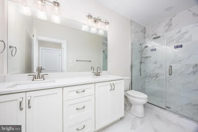 a bathroom with a double vanity sink mirror and toilet