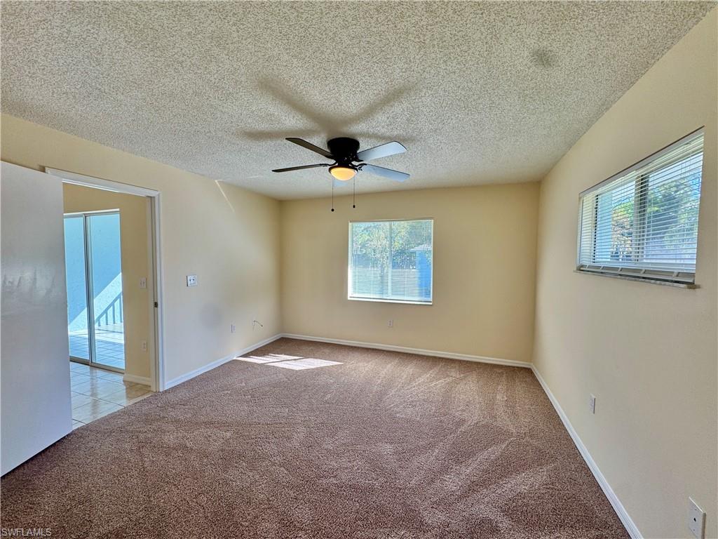 5665 Whitaker Road, Unit A201 Naples, FL 34112 - Photo 15 of 30 an empty room with windows and fan