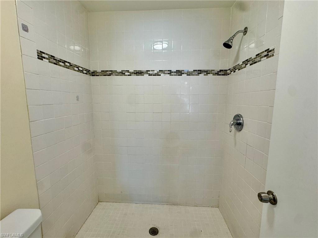 5665 Whitaker Road, Unit A201 Naples, FL 34112 - Photo 17 of 30 a bathroom with a shower and a mirror