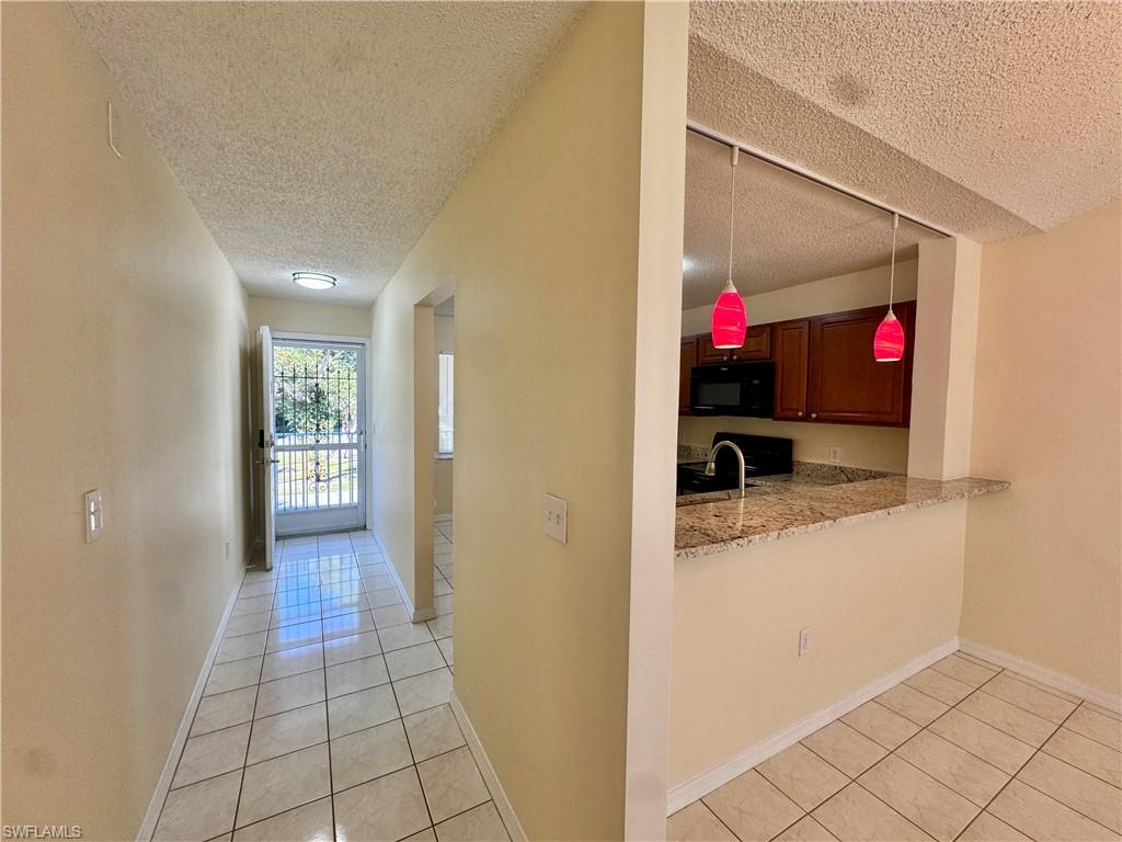 5665 Whitaker Road, Unit A201 Naples, FL 34112 - Photo 18 of 30 a view of a hallway and wooden shelves