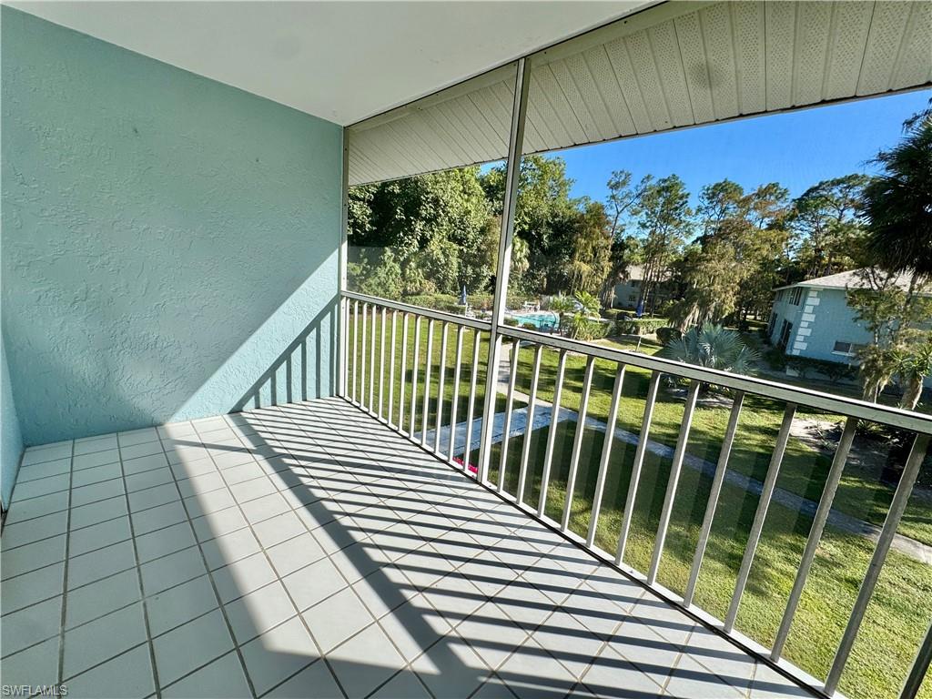 5665 Whitaker Road, Unit A201 Naples, FL 34112 - Photo 21 of 30 a view of a balcony with wooden floor and fence
