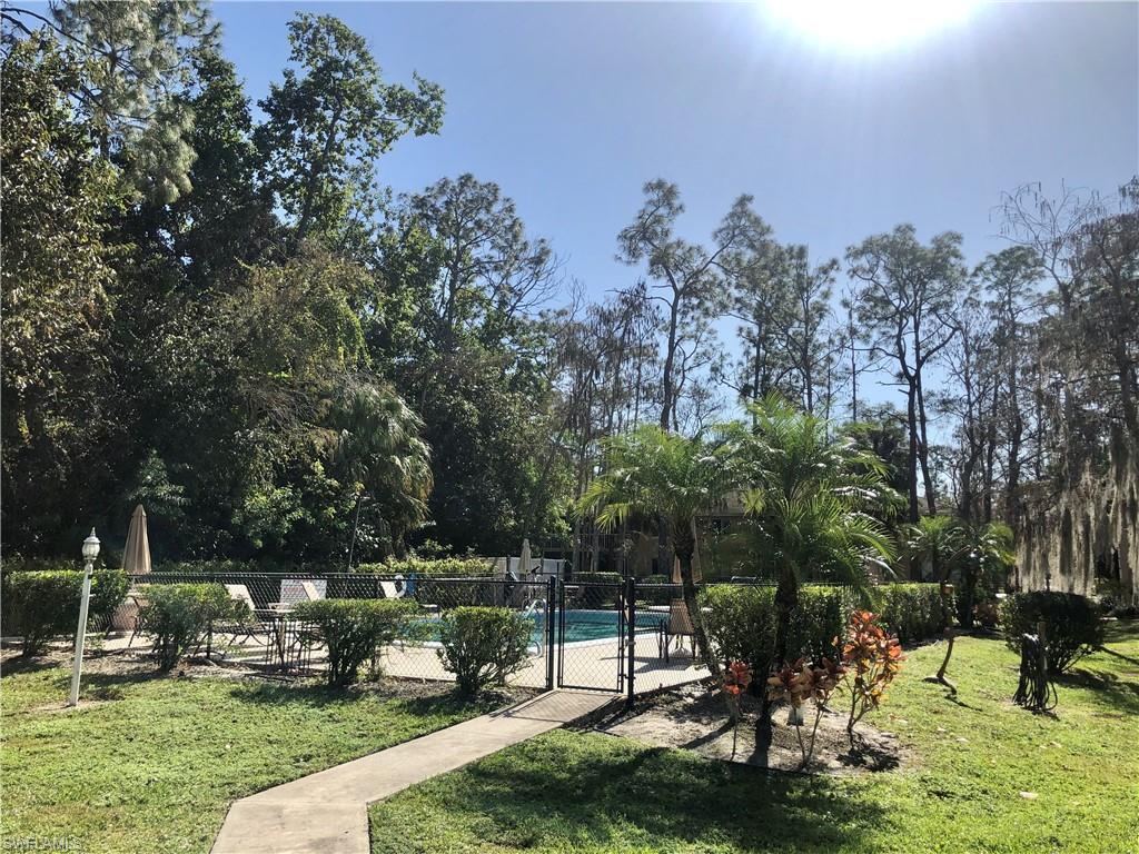 5665 Whitaker Road, Unit A201 Naples, FL 34112 - Photo 29 of 30 a view of a park with large trees