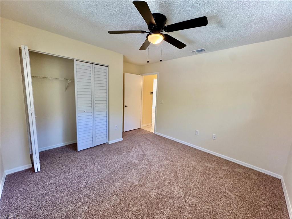 5665 Whitaker Road, Unit A201 Naples, FL 34112 - Photo 9 of 30 an empty room with closet and fan
