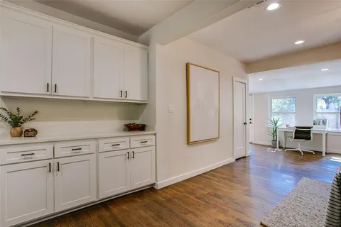 a kitchen with cabinets and wooden floor