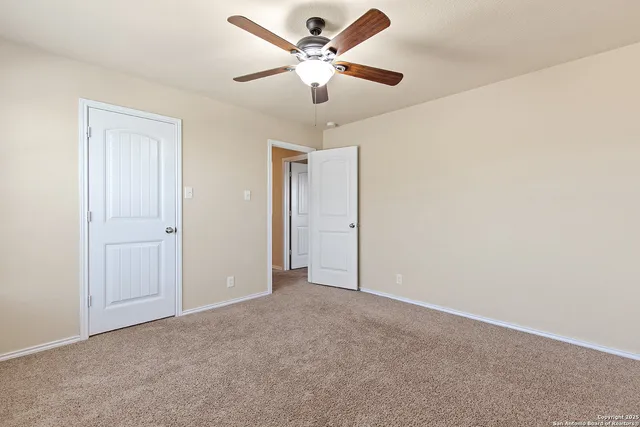 an empty room with a window and ceiling fan