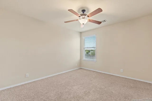 an empty room with chandelier fan