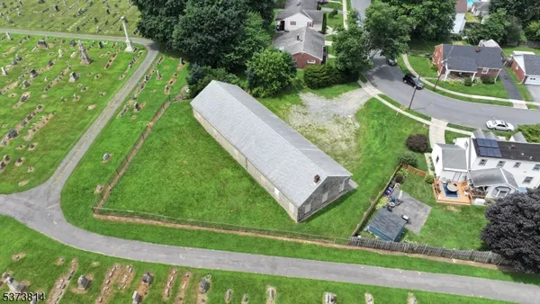 an aerial view of a residential houses with outdoor space and a street view