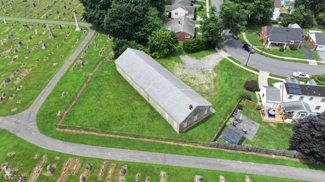 an aerial view of a residential houses with outdoor space and a street view