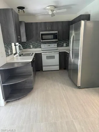a kitchen with a refrigerator sink and cabinets