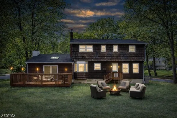 a view of a house with a big yard and large trees