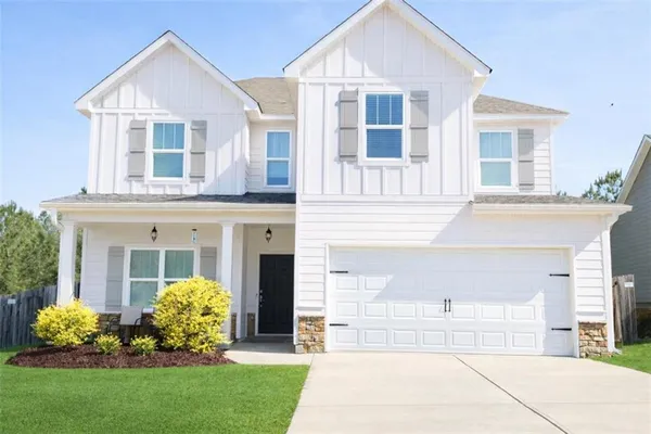 a front view of a house with a garden and plants