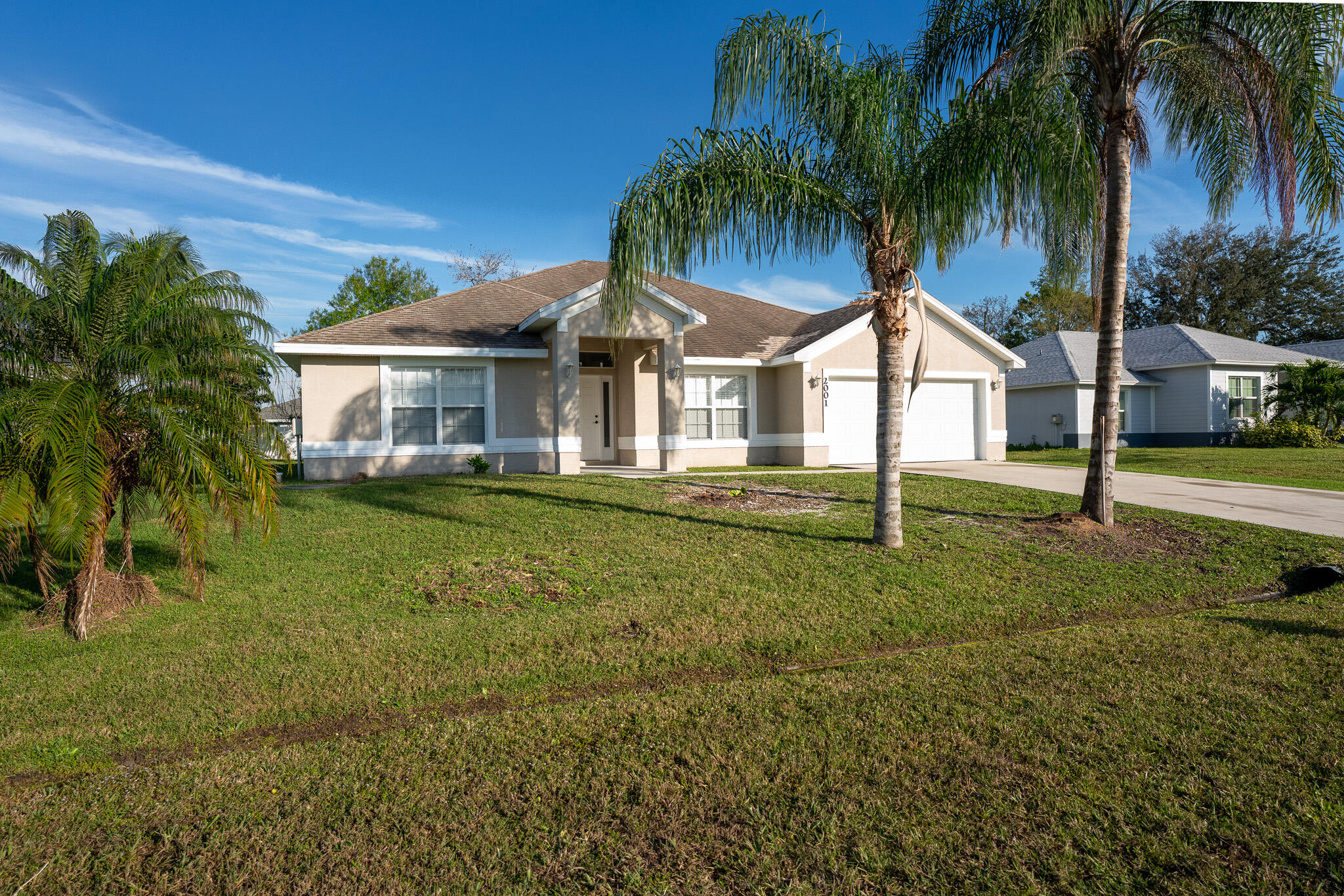 2001 Southwest Ember Street Port St. Lucie, FL 34953 - Photo 1 of 22 a front view of a house with a garden
