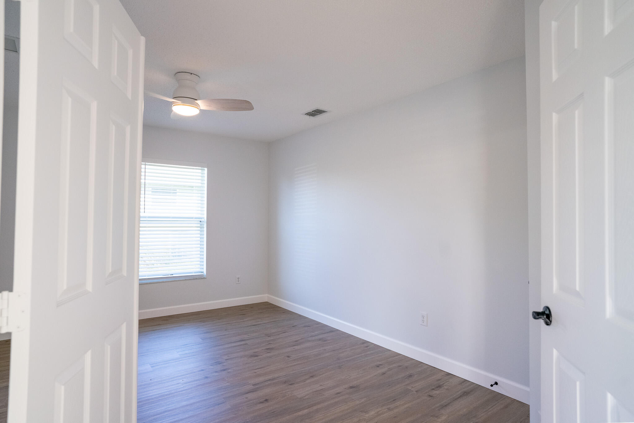 2001 Southwest Ember Street Port St. Lucie, FL 34953 - Photo 15 of 22 a view of an empty room with wooden floor and a window