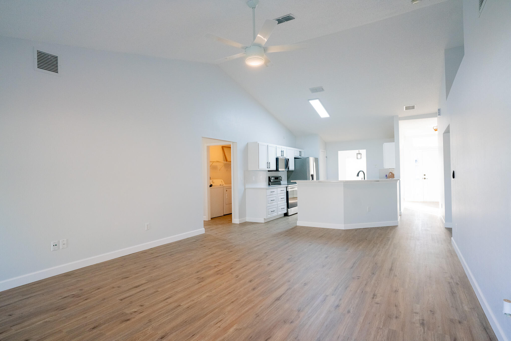 2001 Southwest Ember Street Port St. Lucie, FL 34953 - Photo 3 of 22 a view of empty room with wooden floor and kitchen