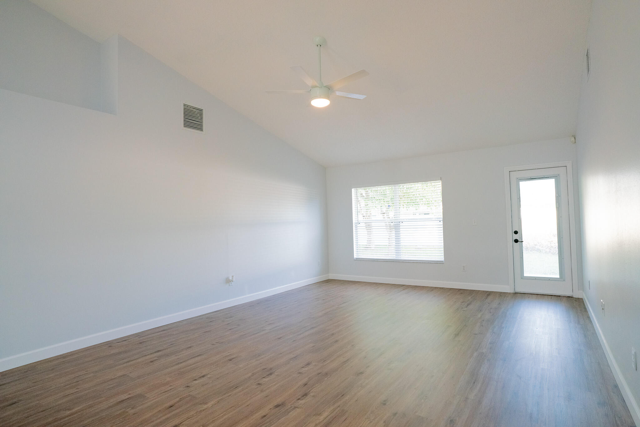 2001 Southwest Ember Street Port St. Lucie, FL 34953 - Photo 4 of 22 an empty room with wooden floor and windows