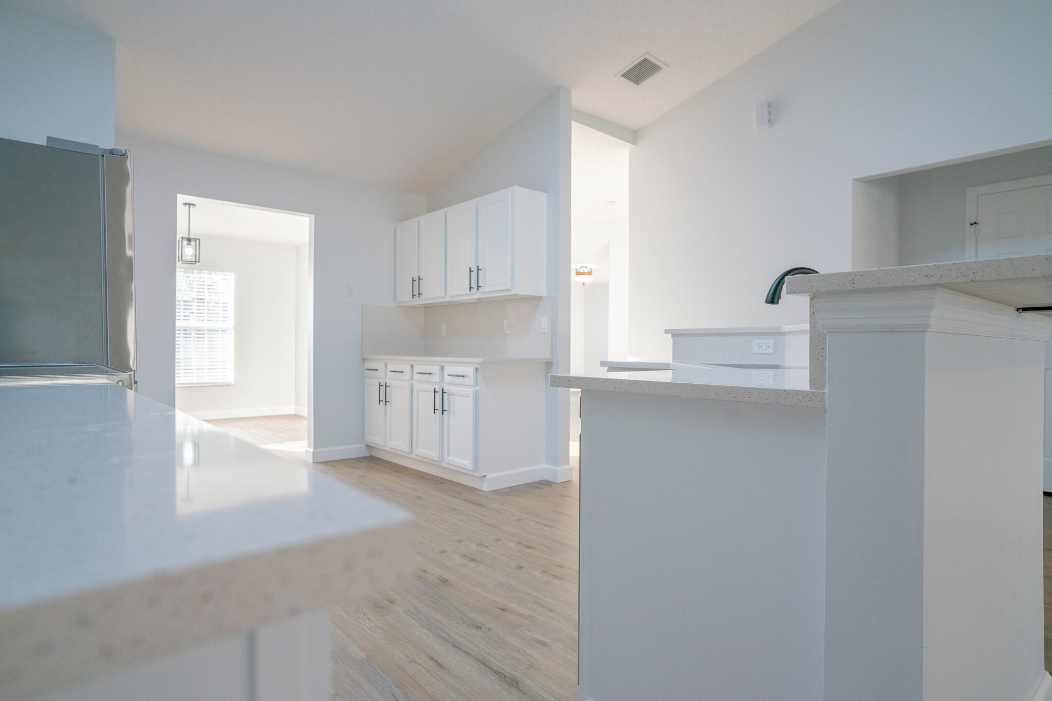 2001 Southwest Ember Street Port St. Lucie, FL 34953 - Photo 7 of 22 a kitchen with granite countertop white cabinets and window