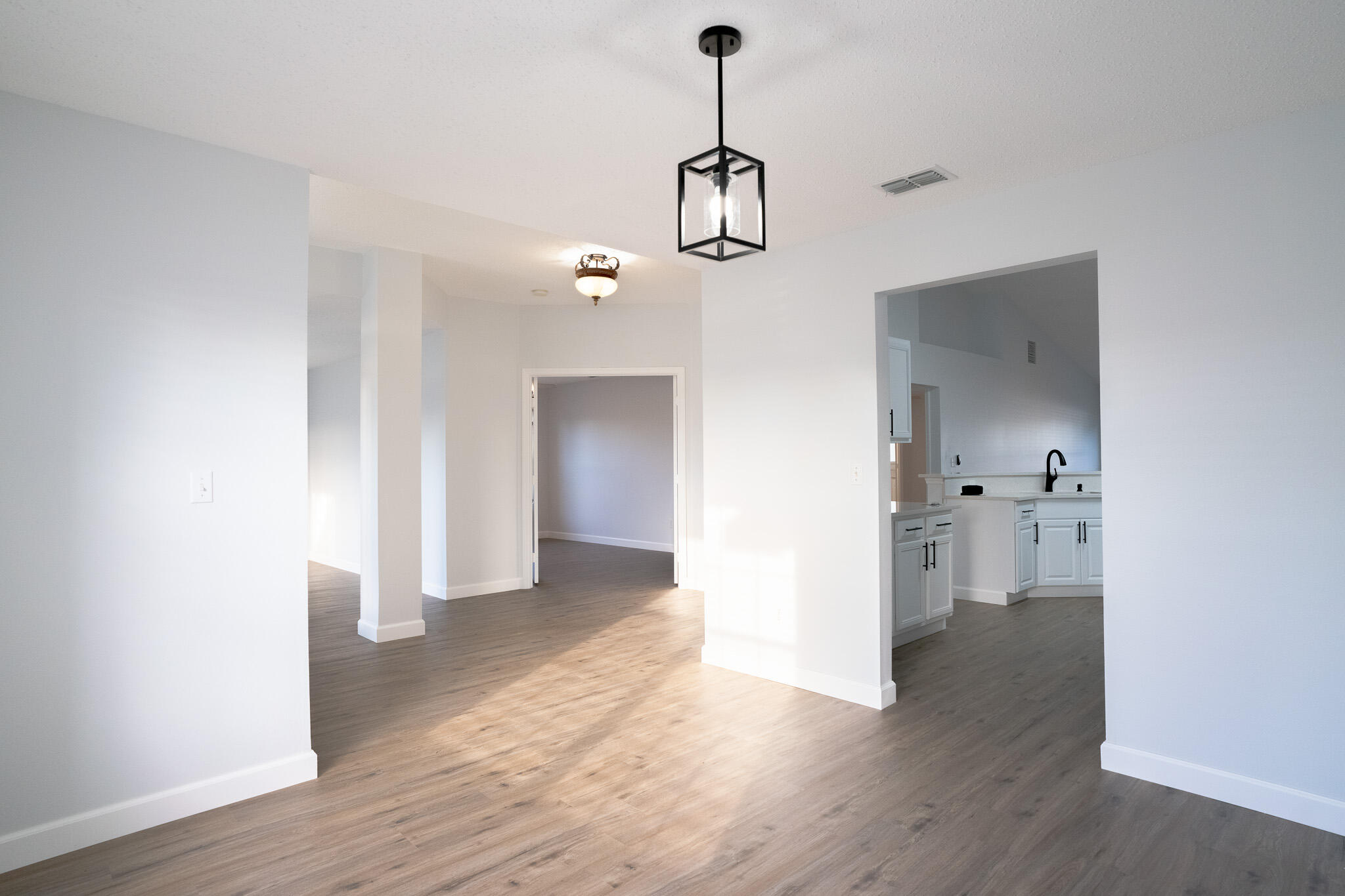 2001 Southwest Ember Street Port St. Lucie, FL 34953 - Photo 9 of 22 a view of a room with wooden floor and a ceiling fan