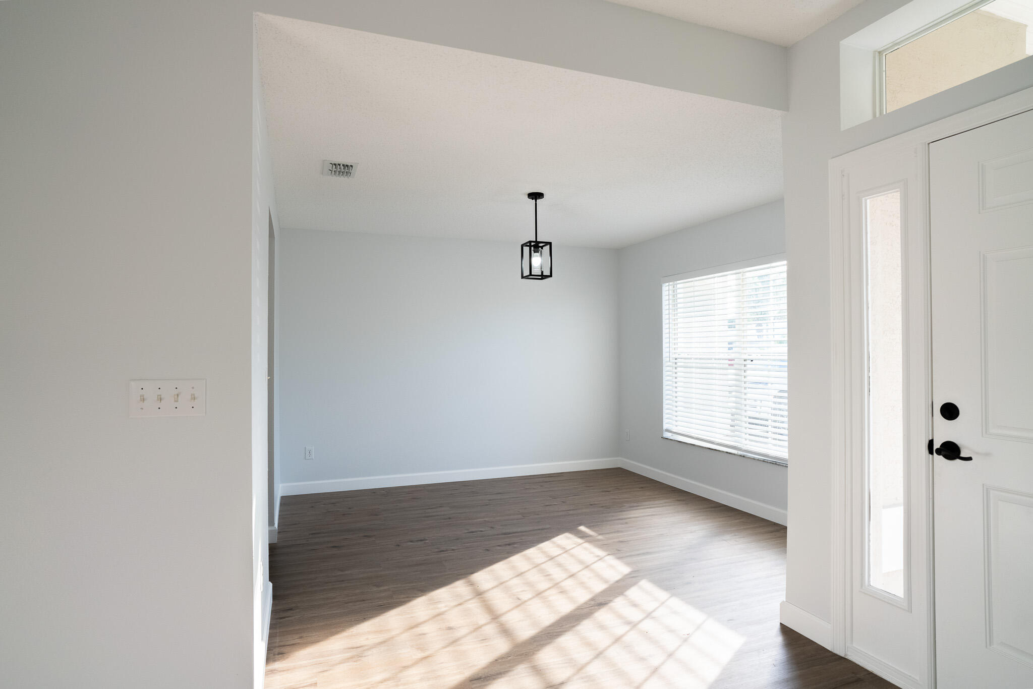 2001 Southwest Ember Street Port St. Lucie, FL 34953 - Photo 10 of 22 a view of an empty room with wooden floor and a window