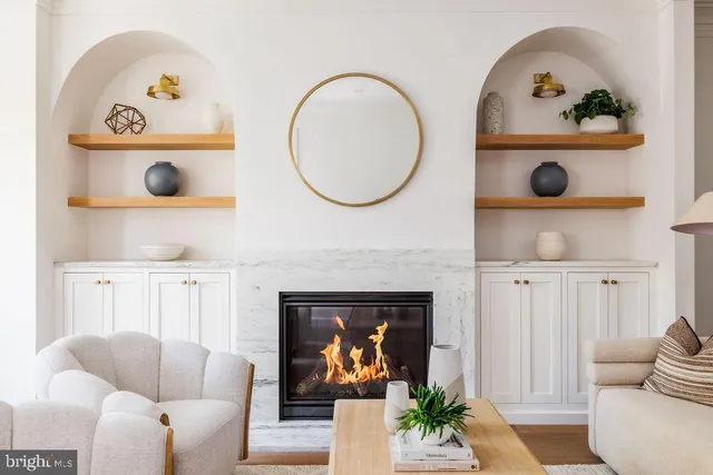 a living room with furniture a fireplace and a chandelier
