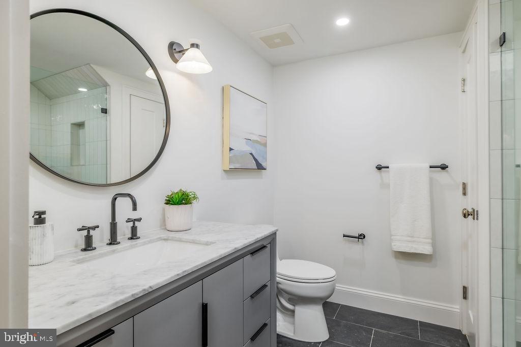 2460 Ontario Road Northwest Washington, DC 20009 - Photo 72 of 85 a bathroom with a granite countertop sink a toilet and a mirror