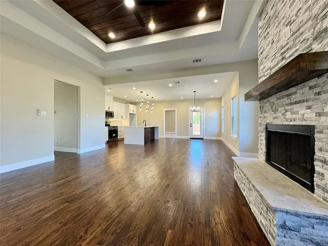 an empty room with wooden floor and fireplace