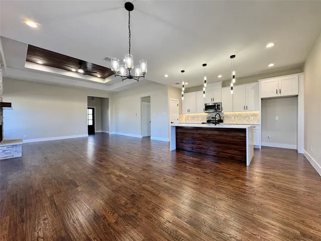 a kitchen with granite countertop a sink cabinets and stainless steel appliances