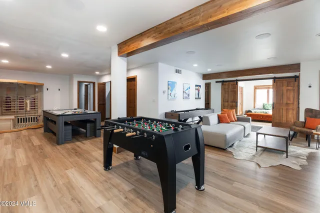 a living room with furniture a wooden floor and next to a window