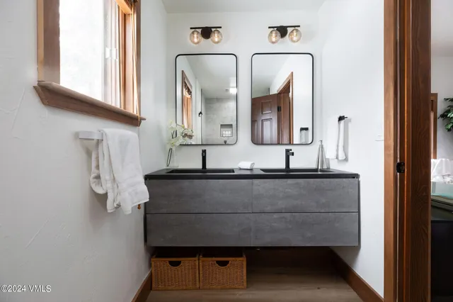 a bathroom with mirror and window
