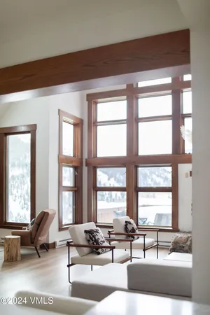 a living room with furniture and floor to ceiling windows