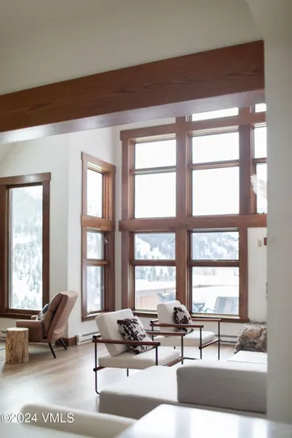 a living room with furniture and floor to ceiling windows