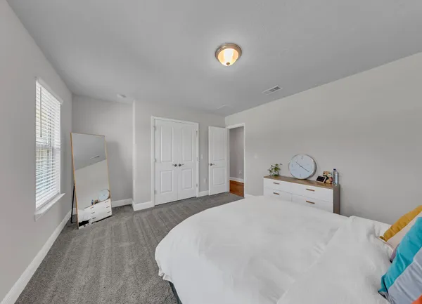 a bed sitting in a bedroom next to a window